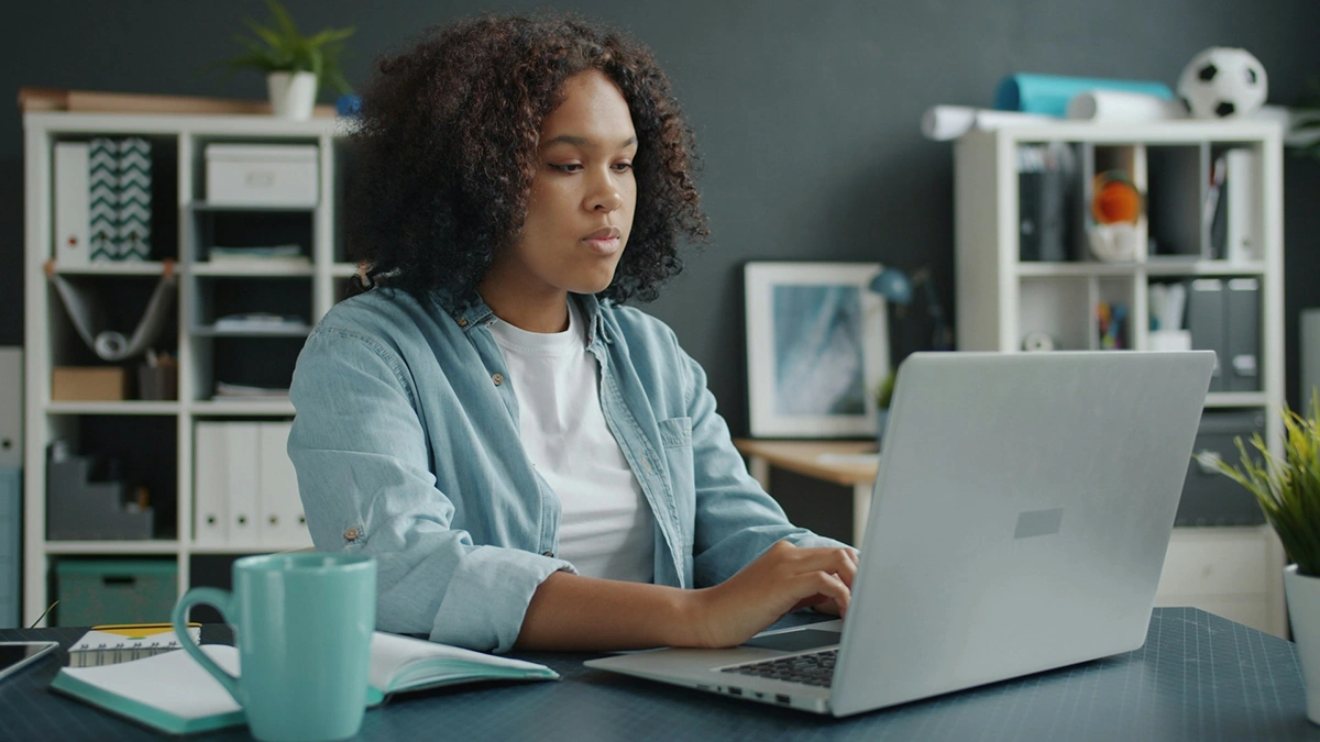Content creator planning work with laptop notebook and camera in a home office